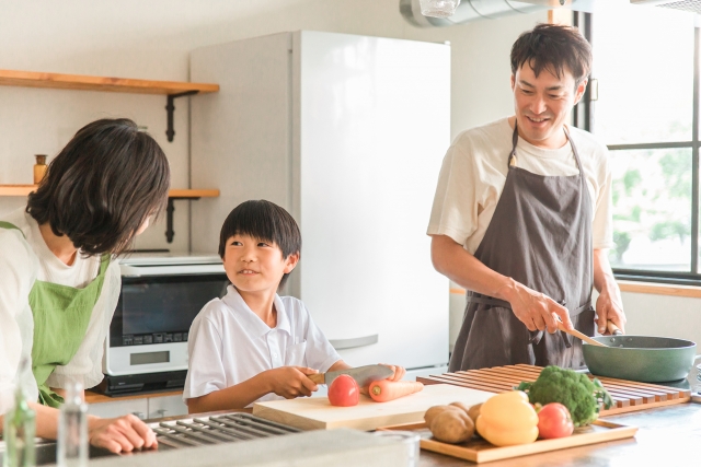 笑顔で料理する三人家族